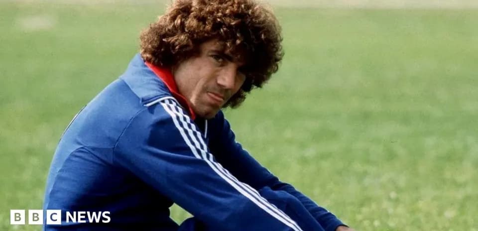 Player sitting on grass field in sports attire