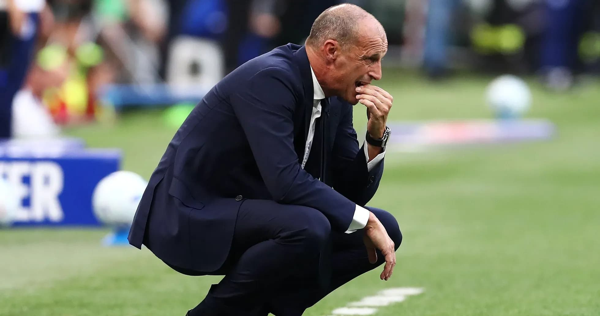 Coach kneeling on the sideline during match
