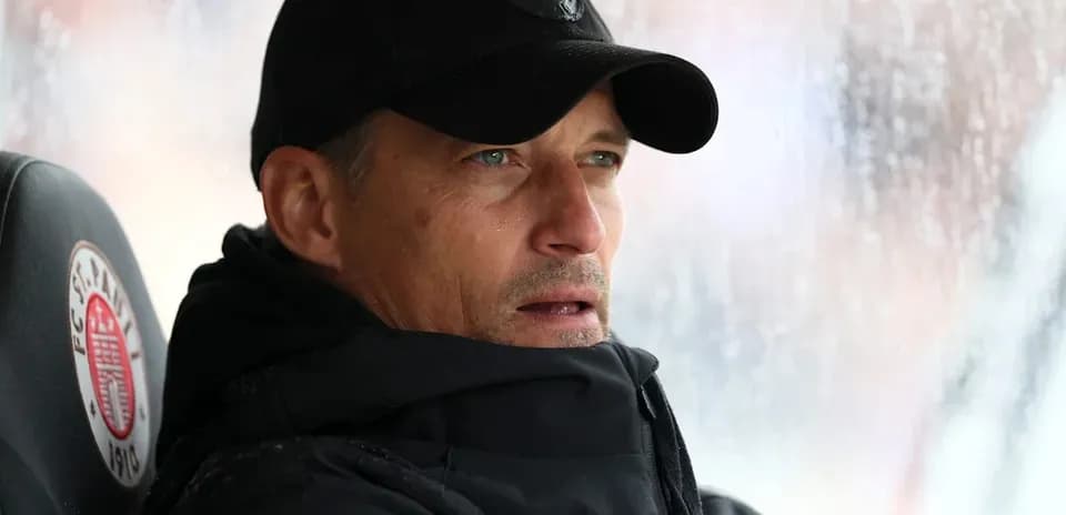 Coach sitting on bench during rainy match