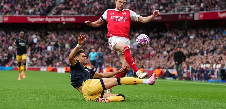 Arsenal player avoiding a tackle during match