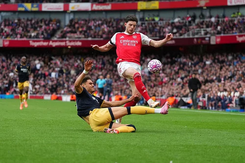 Arsenal player avoiding a tackle during match