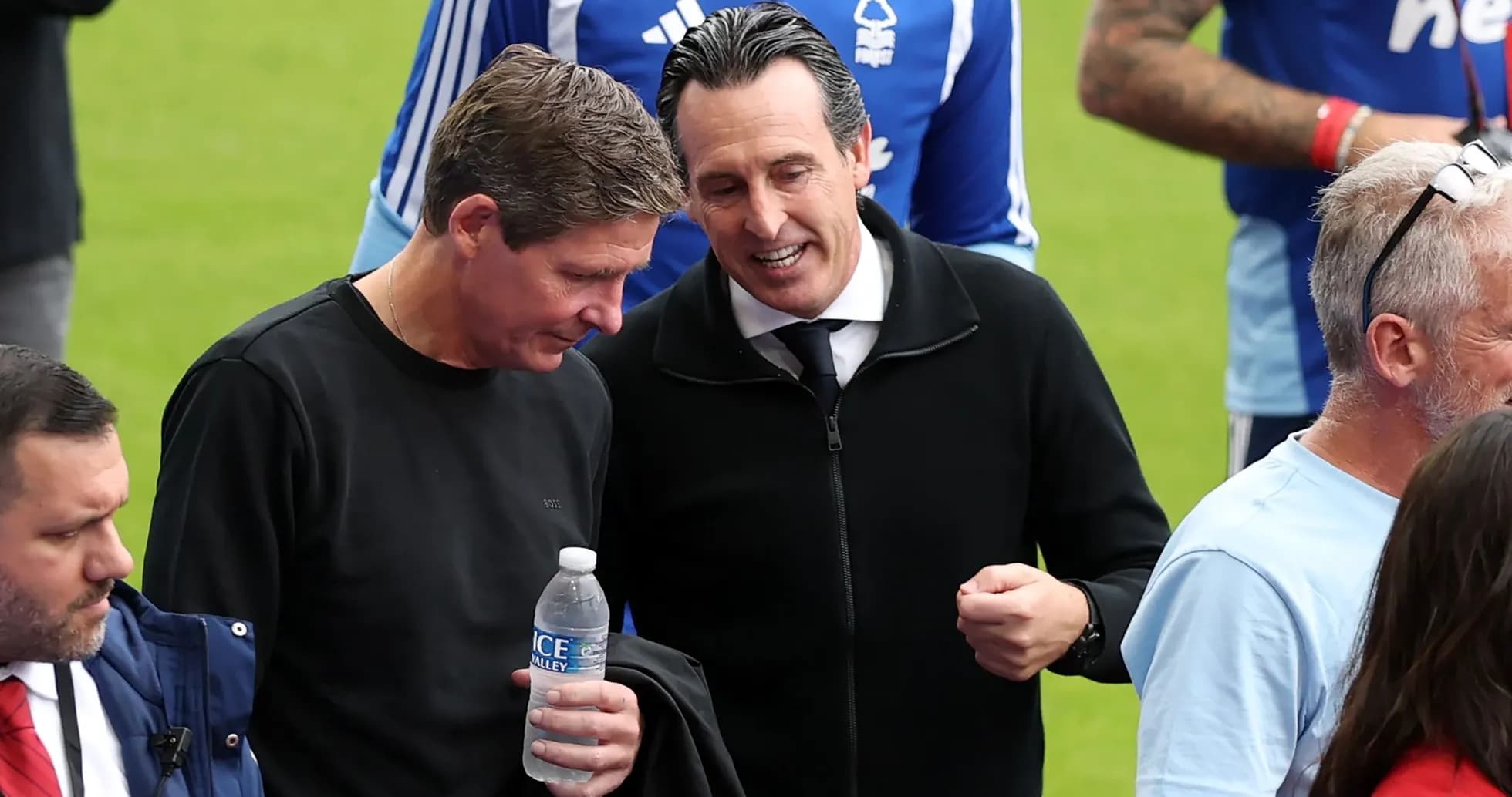 Two men conversing on the pitch before a match