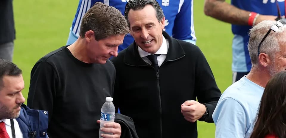 Two men conversing on the pitch before a match