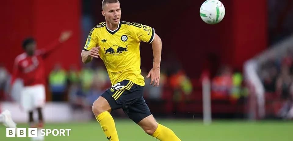 Player in yellow jersey chasing a ball on field