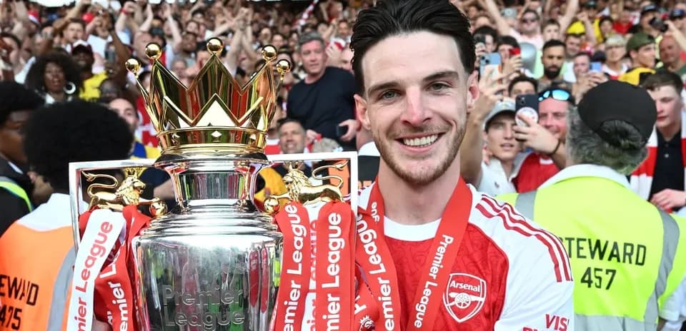 Player holding Premier League trophy in celebration