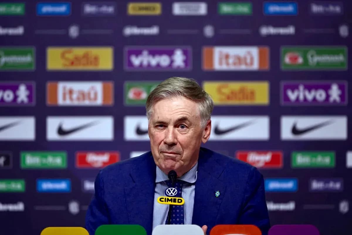 Coach speaking at press conference with logos in background