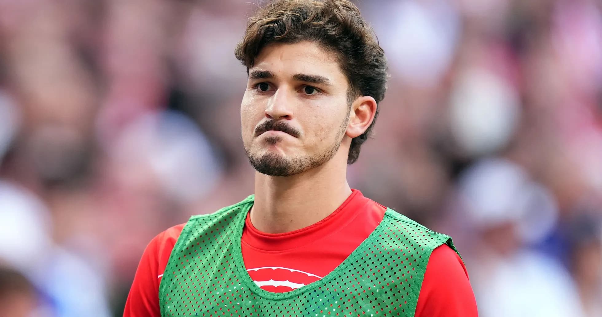 Player in training bib on the sidelines
