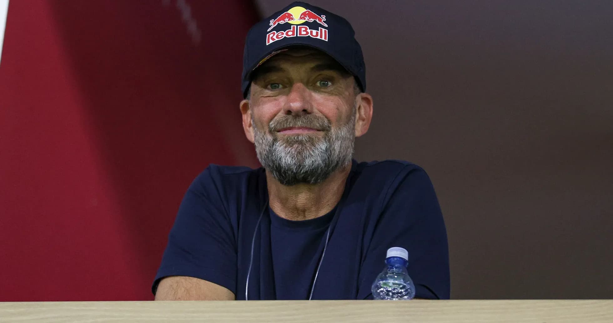 Man with beard wearing a Red Bull cap