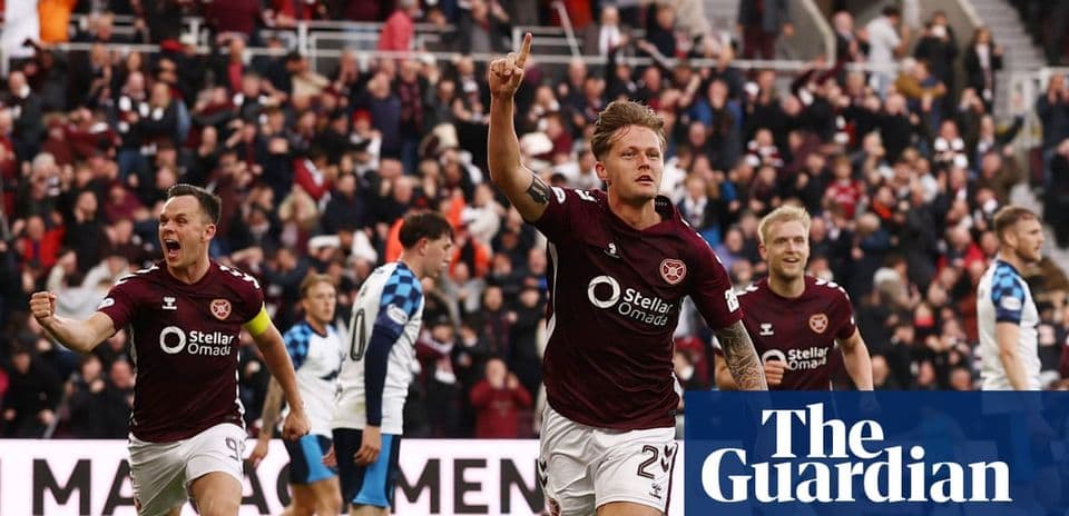Hearts player celebrating a goal with fans cheering