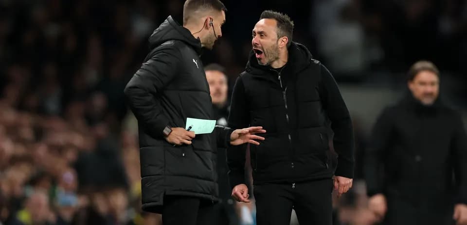 Two coaches discussing animatedly on the sidelines