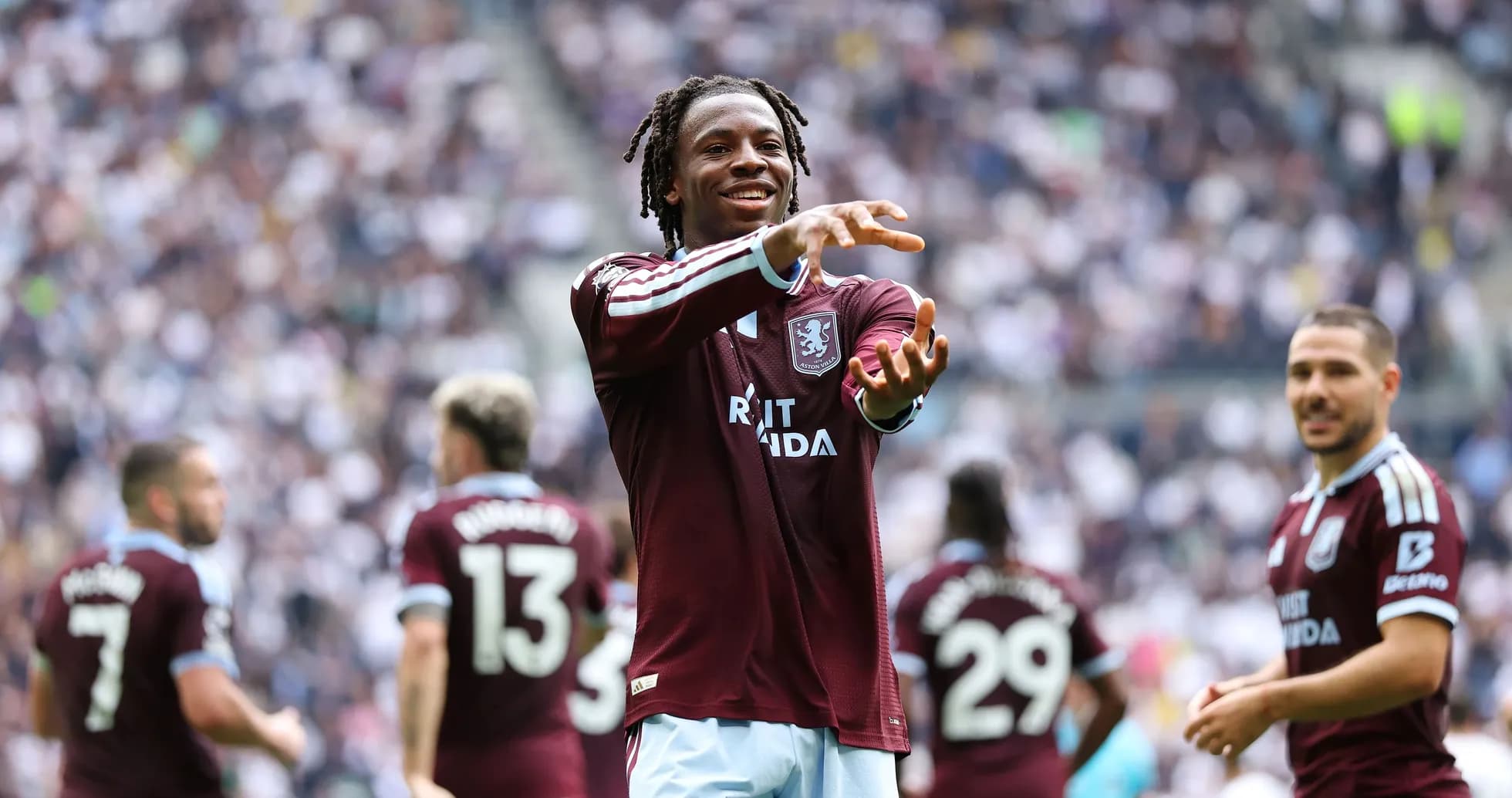 Aston Villa player celebrating with teammates on field