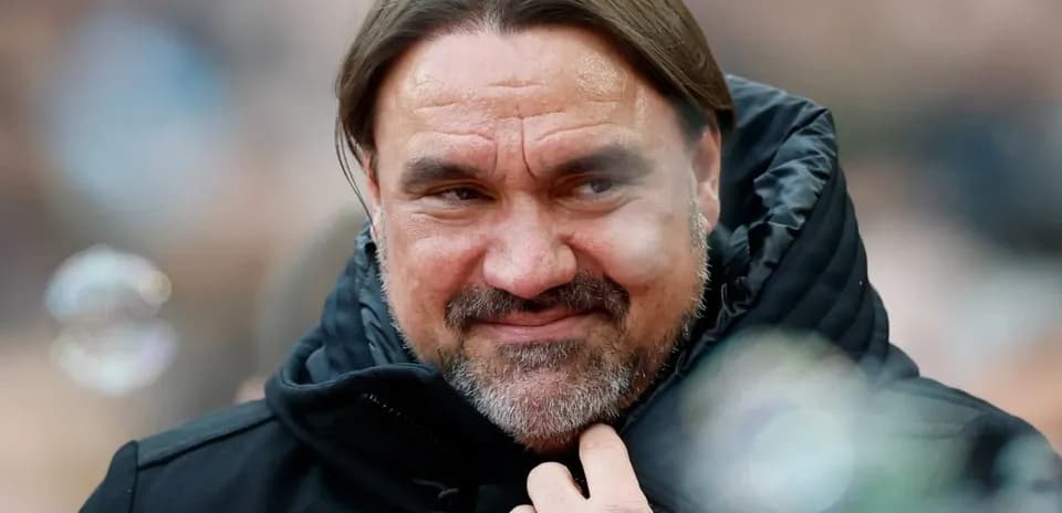 Coach in a black jacket smiling at event