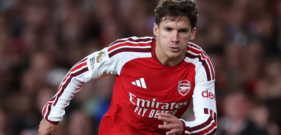 Player sprinting in Arsenal home kit during match