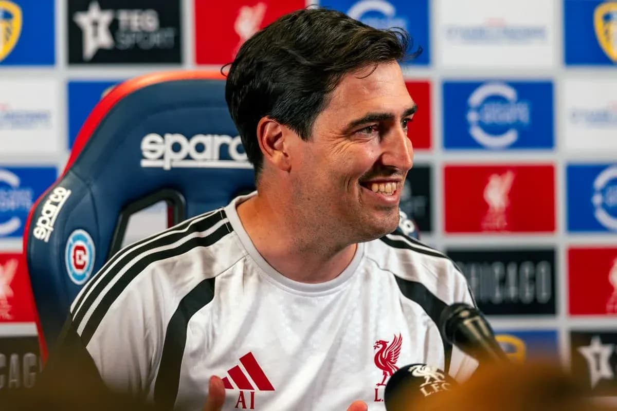 Manager speaking at press conference with Liverpool backdrop