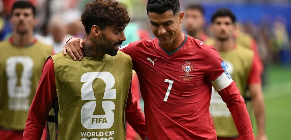 Two Portugal players walking off the pitch together