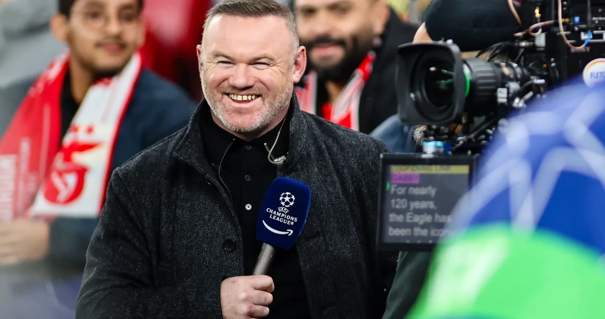 Presenter smiling with microphone at Champions League event