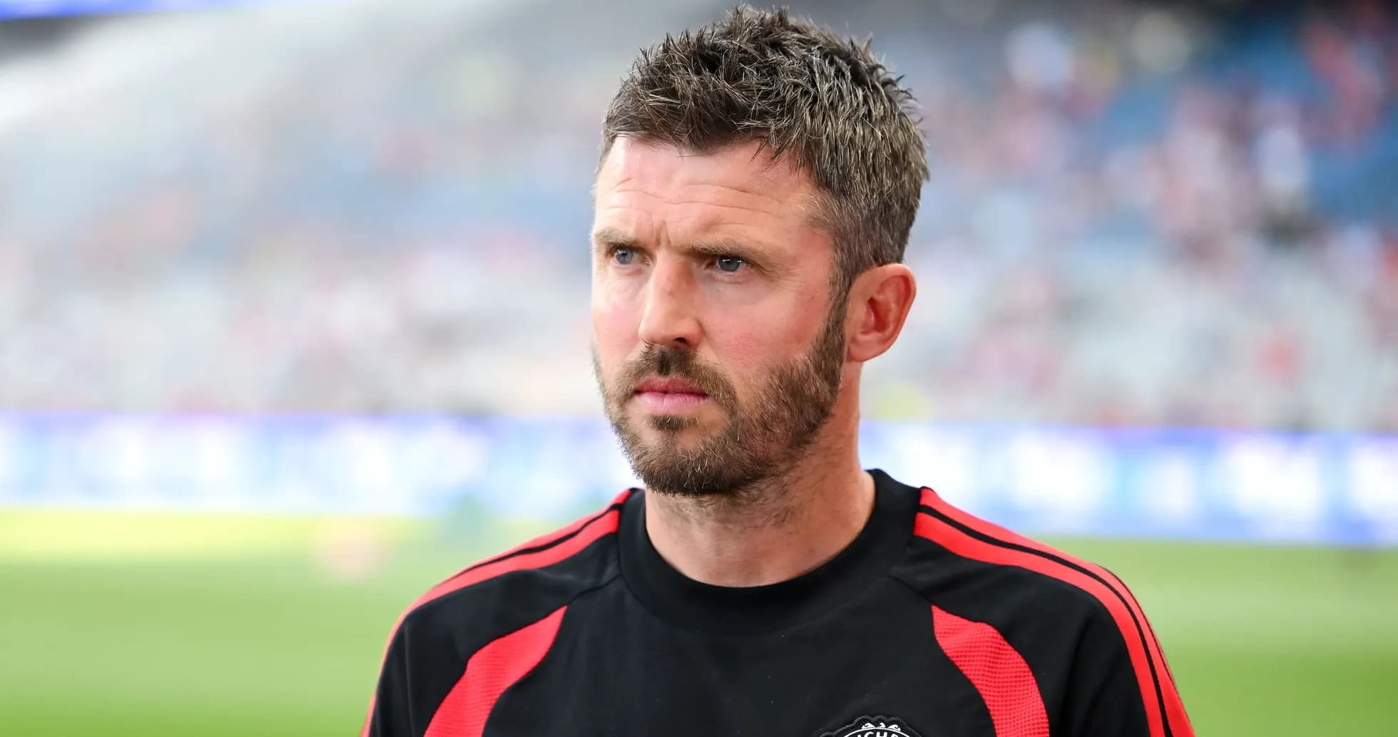 Coach wearing Manchester United kit on the sidelines