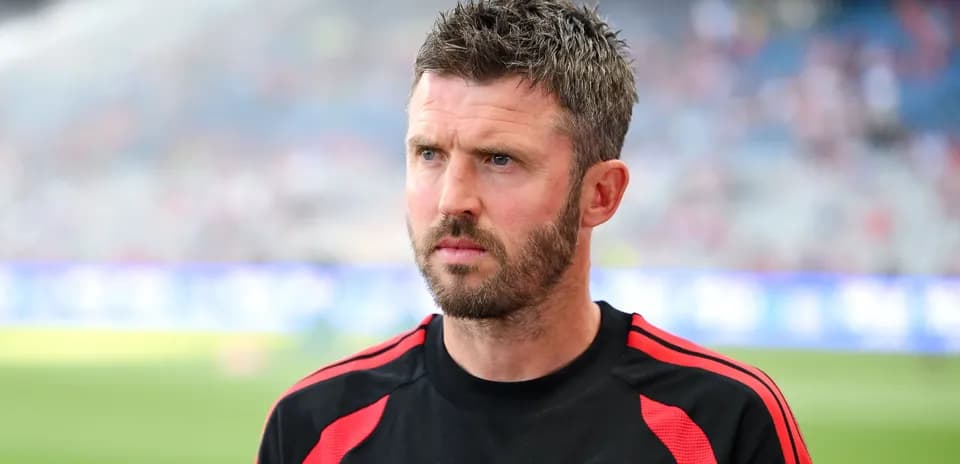 Coach wearing Manchester United kit on the sidelines