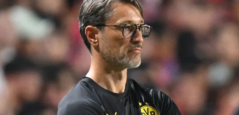 Coach observing match with arms crossed