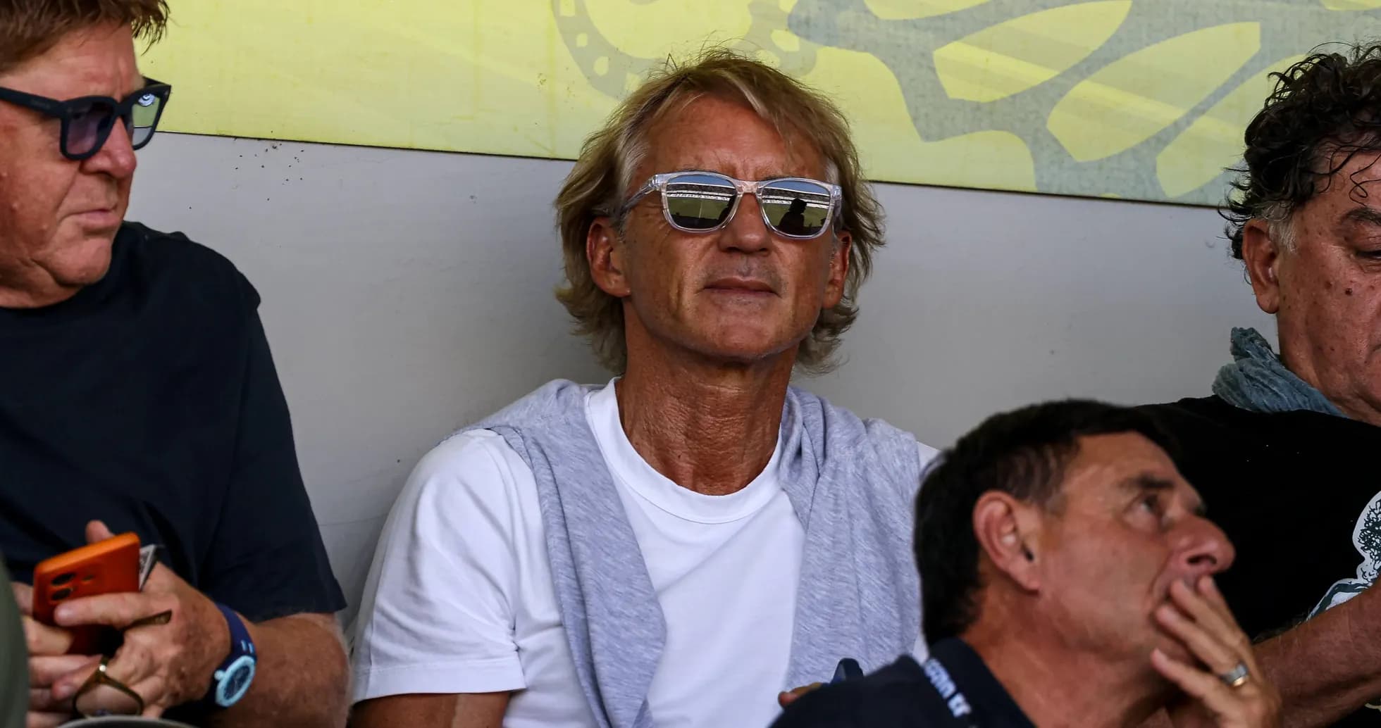 Man wearing sunglasses sitting among spectators