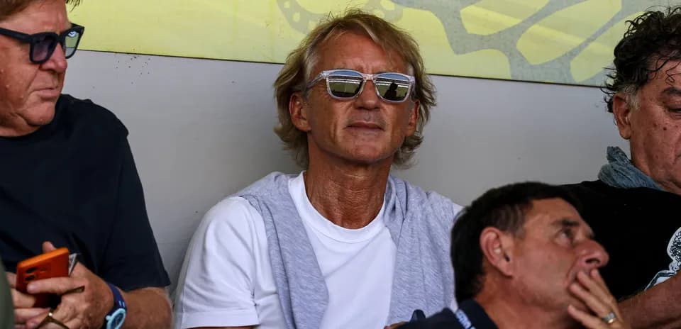 Man wearing sunglasses sitting among spectators
