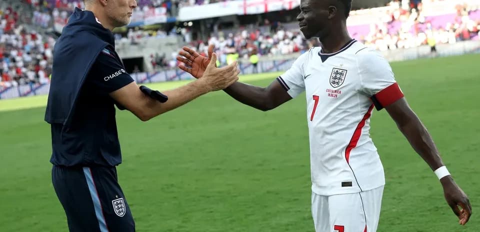 Coach and player exchanging handshakes on pitch
