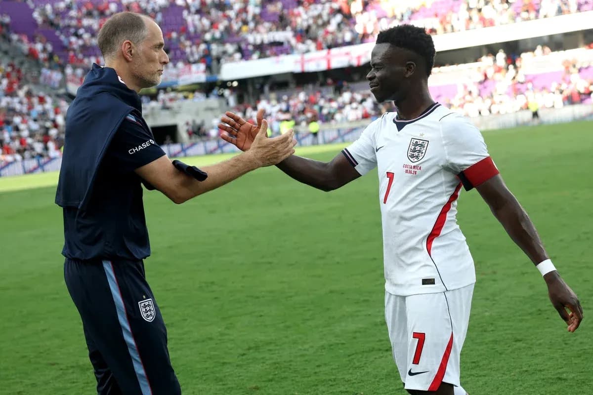 Coach and player exchanging handshakes on pitch