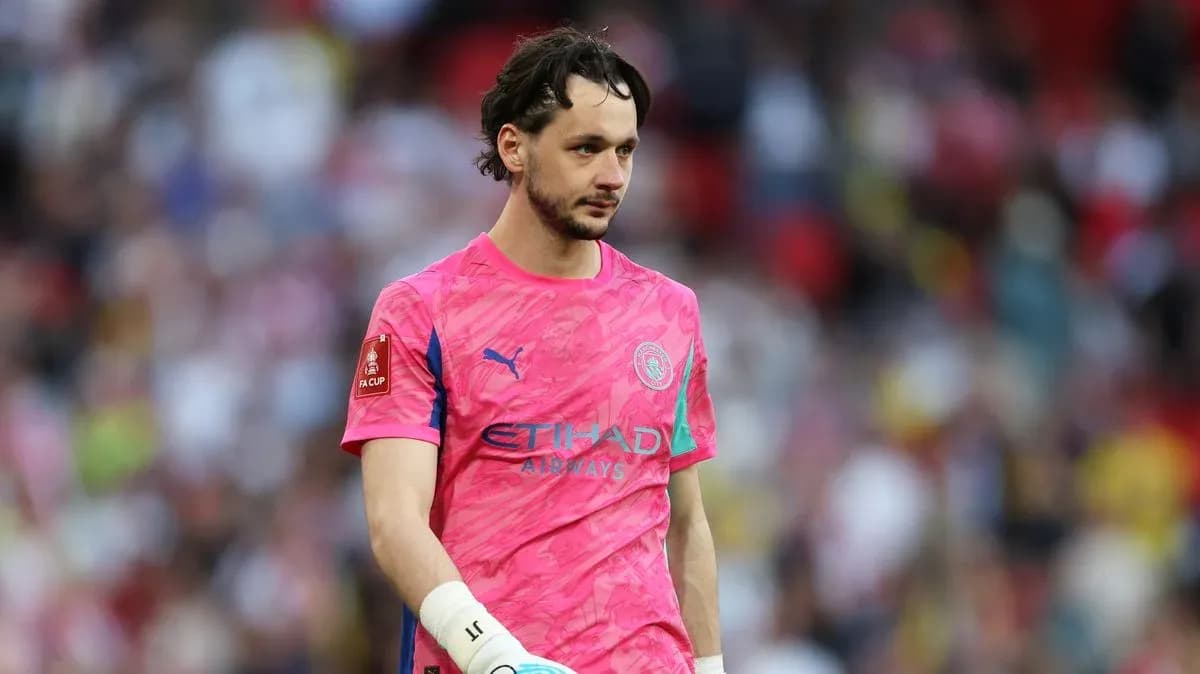 Goalkeeper in pink jersey walking on the pitch