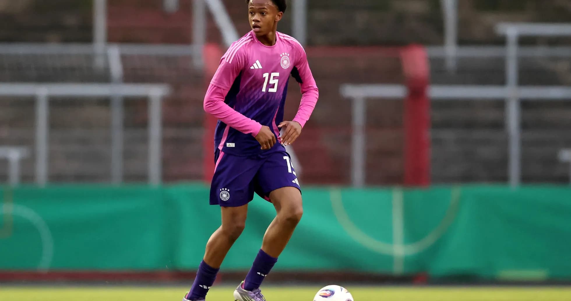 Player in Germany kit dribbling soccer ball on field