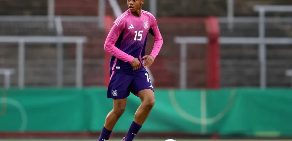 Player in Germany kit dribbling soccer ball on field