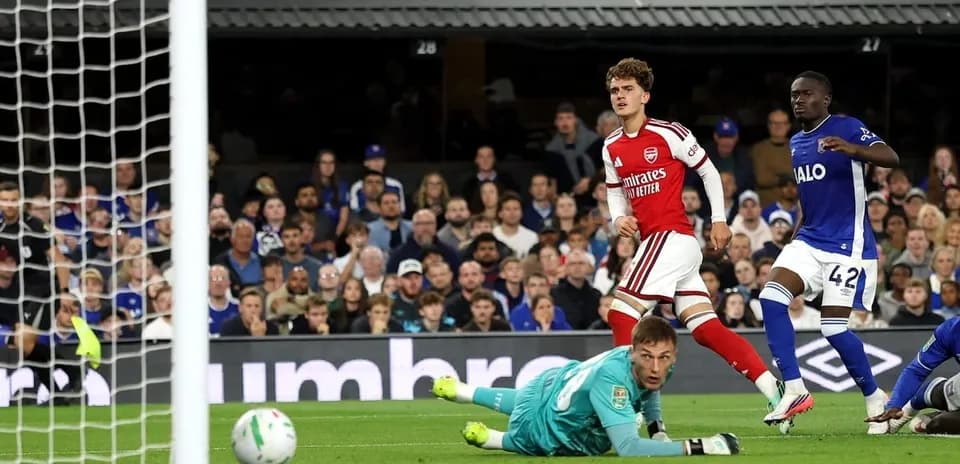Arsenal player celebrates scoring against the goalkeeper