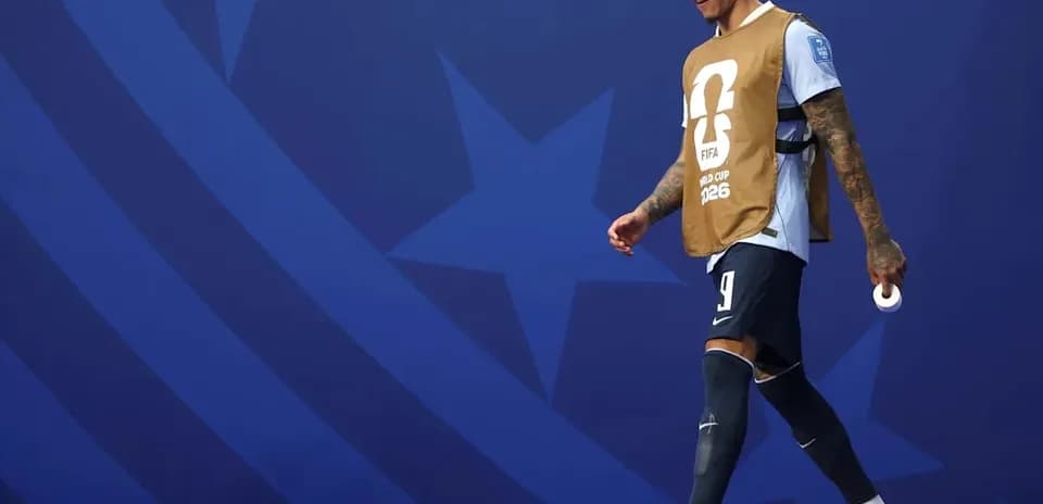Player walking on pitch wearing training bib
