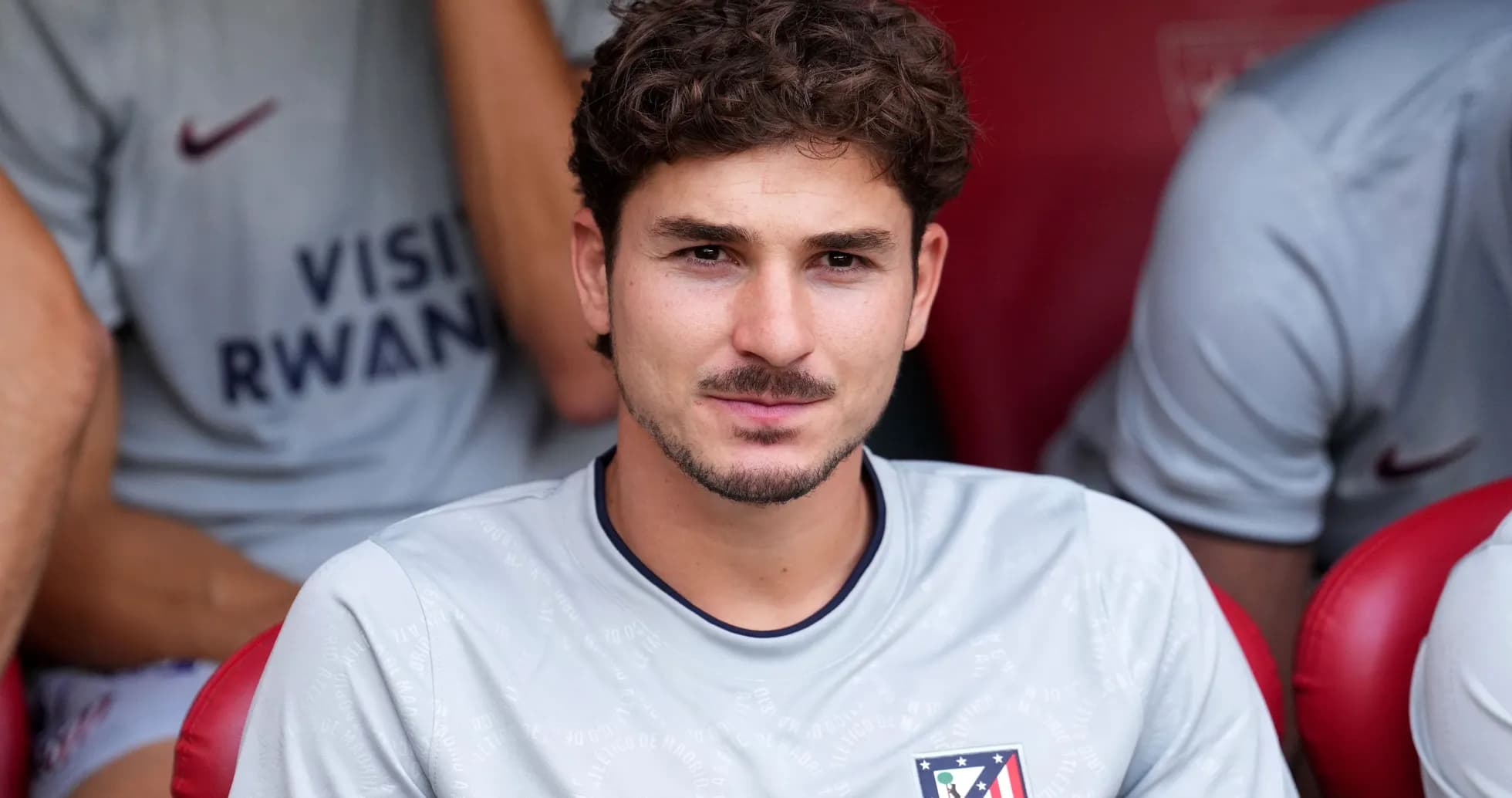 Player seated on bench wearing Atlético Madrid jersey