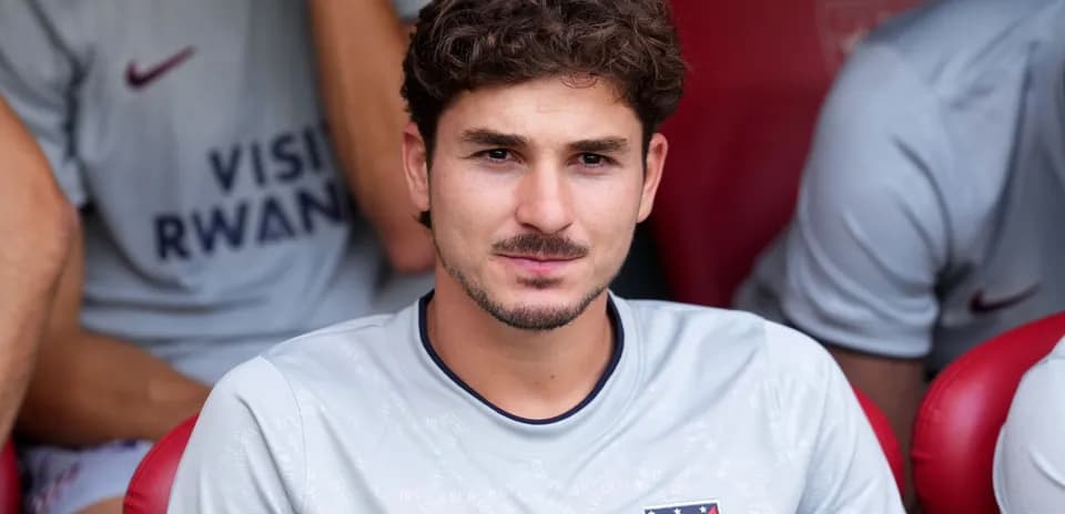 Player seated on bench wearing Atlético Madrid jersey