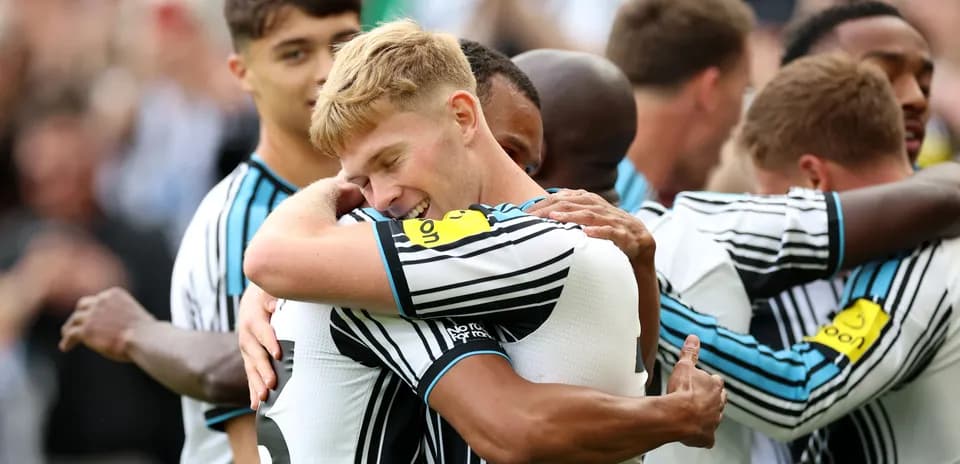 Players celebrating with hugs after scoring a goal