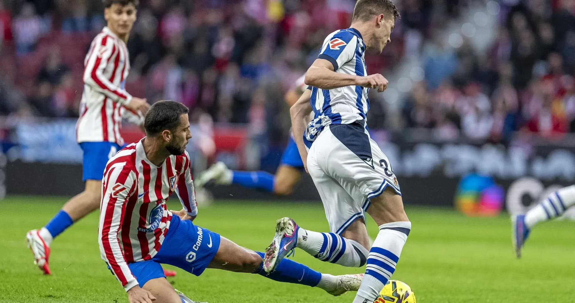 Real Sociedad player evading Atletico Madrid tackle