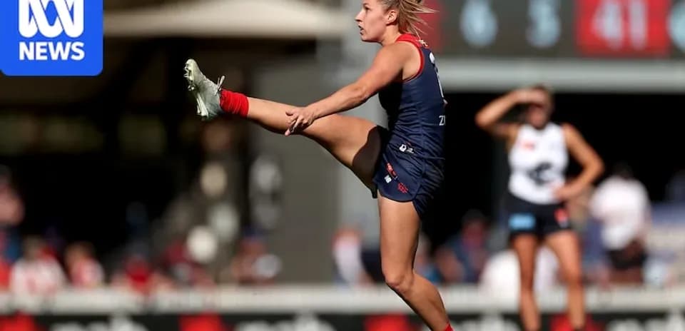 Player kicking the ball during Australian rules football match