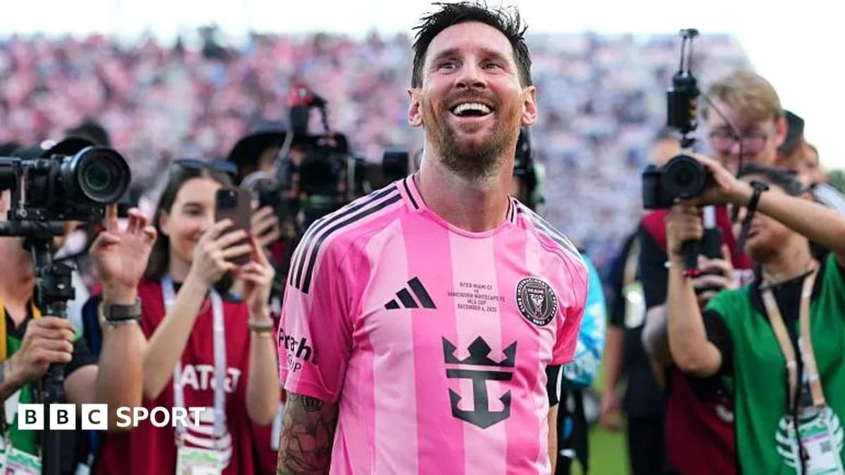 Lionel Messi smiling surrounded by photographers