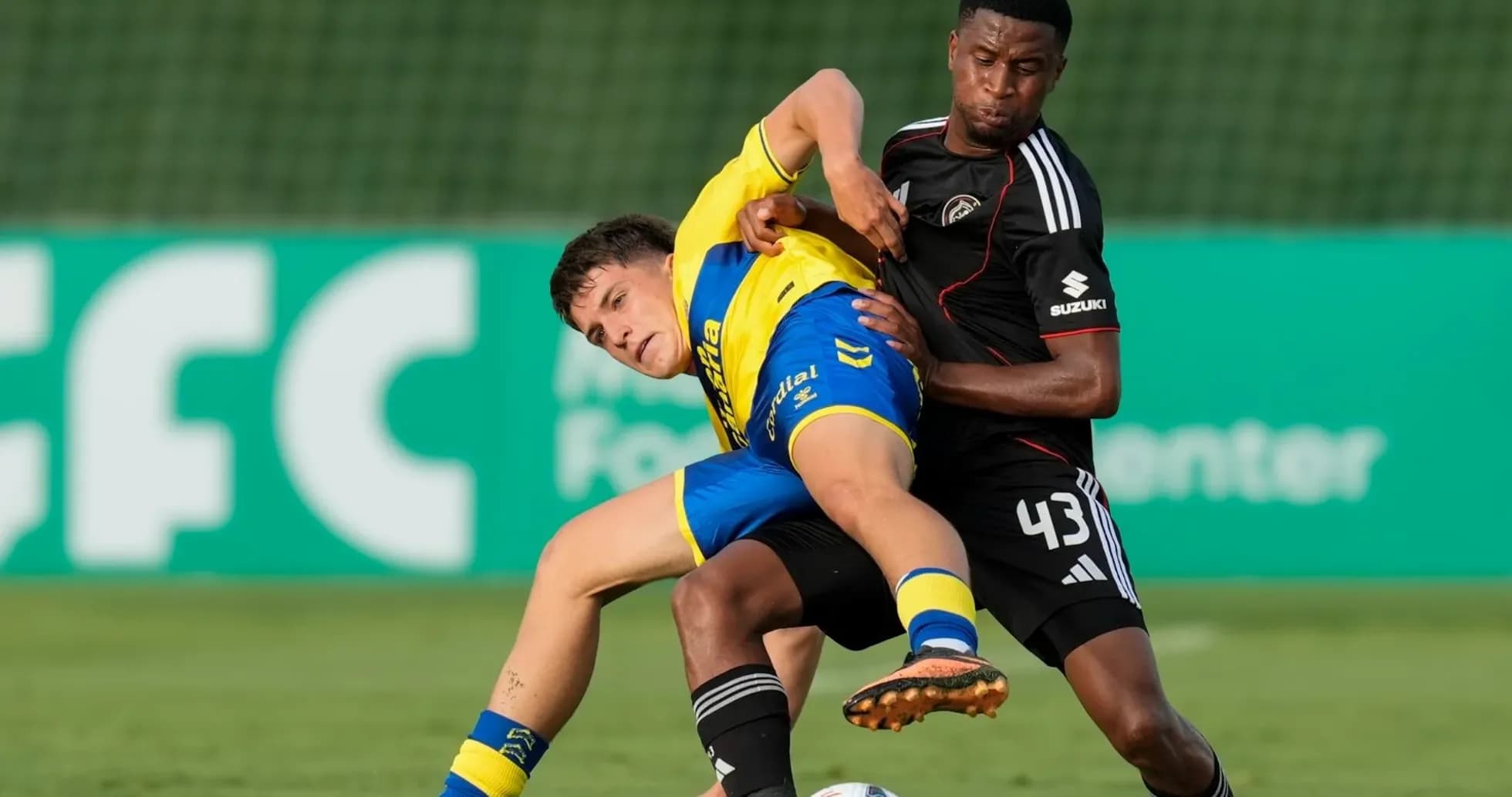 Two players contesting the ball on the field