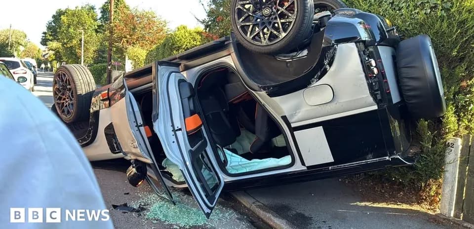 Upside-down car on roadside with broken glass