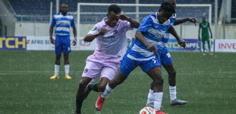 Players battling for the ball in rainy match