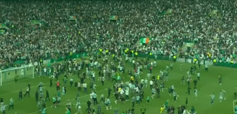Crowd celebrating on the pitch after a match