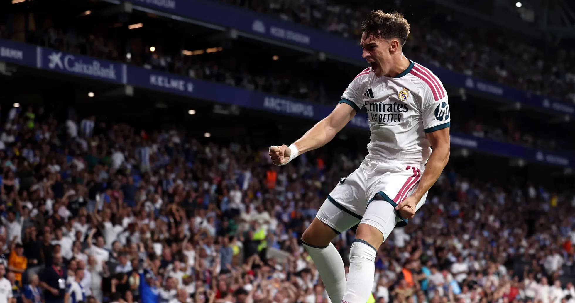 Player celebrating a goal with fans in stadium
