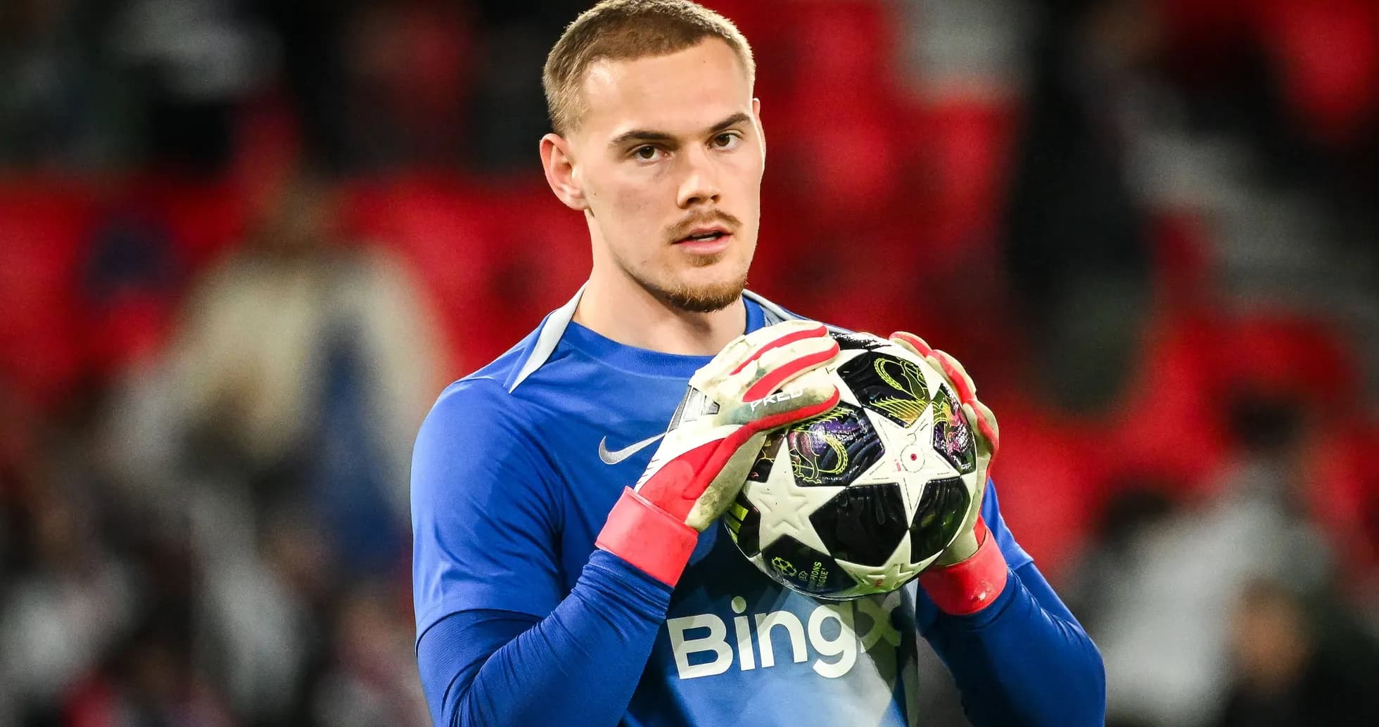 Goalkeeper holding ball before match at stadium