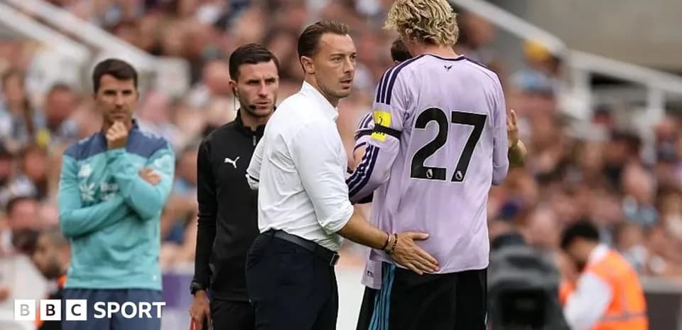 Coach talking to goalkeeper during match substitution