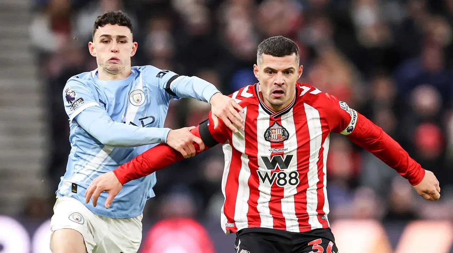 Manchester City player challenging Sunderland player