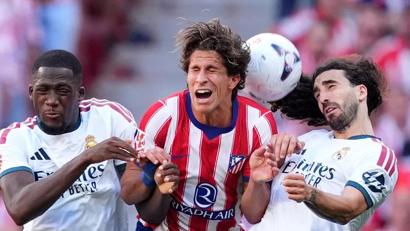 Players from Atletico and Real Madrid contesting a header
