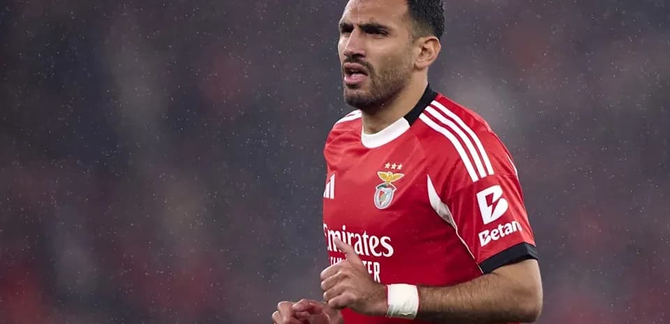 Player wearing Benfica kit during rainy match