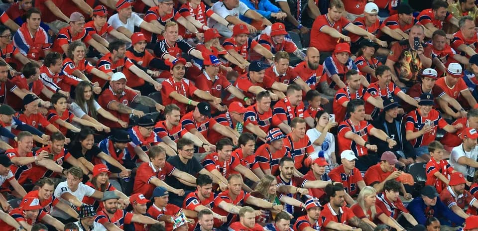 Crowd of fans wearing red cheering at event
