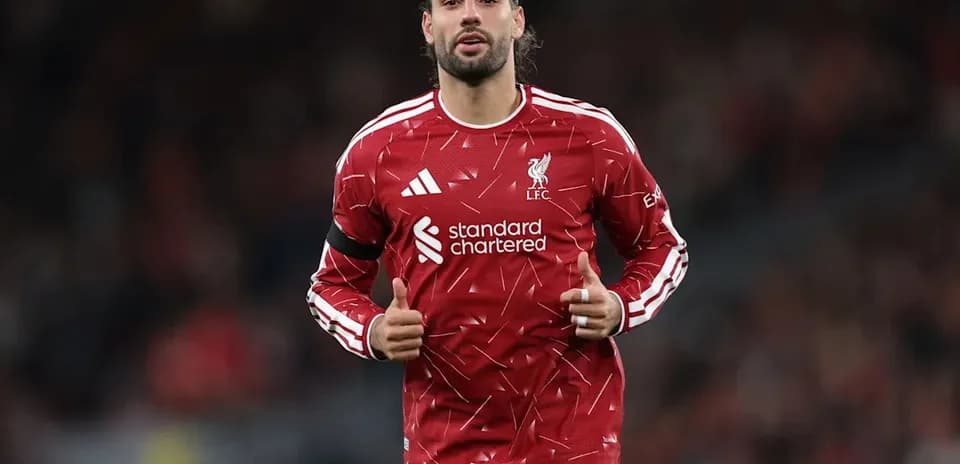 Player warming up in Liverpool kit at stadium